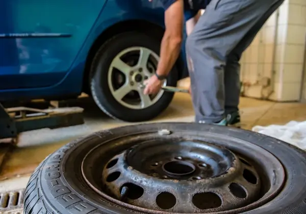 Man tightening car tyre bolts with torque wrench