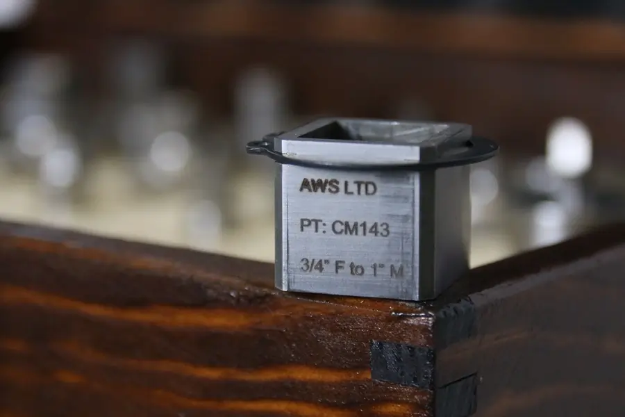AWS Precision Torque Adapter sat atop a wooden container with several other adapters inside