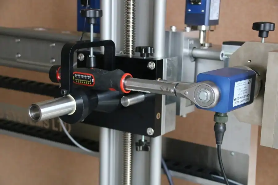 Small torque wrench being calibrated by a machine