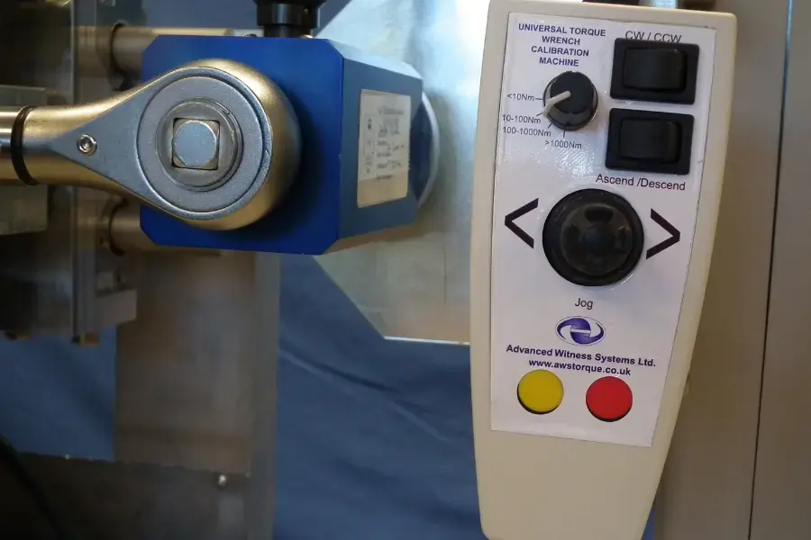 Torque wrench calibrator controller showing switches, dials, joysticks and buttons