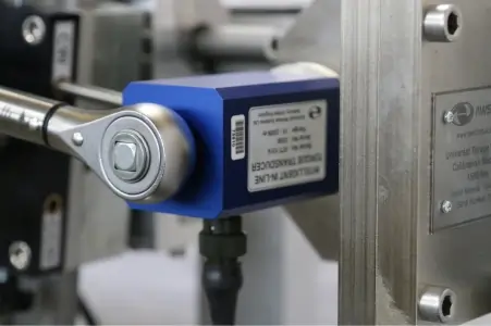 Close up of a torque wrench applying torque to a transducer in a calibration machine